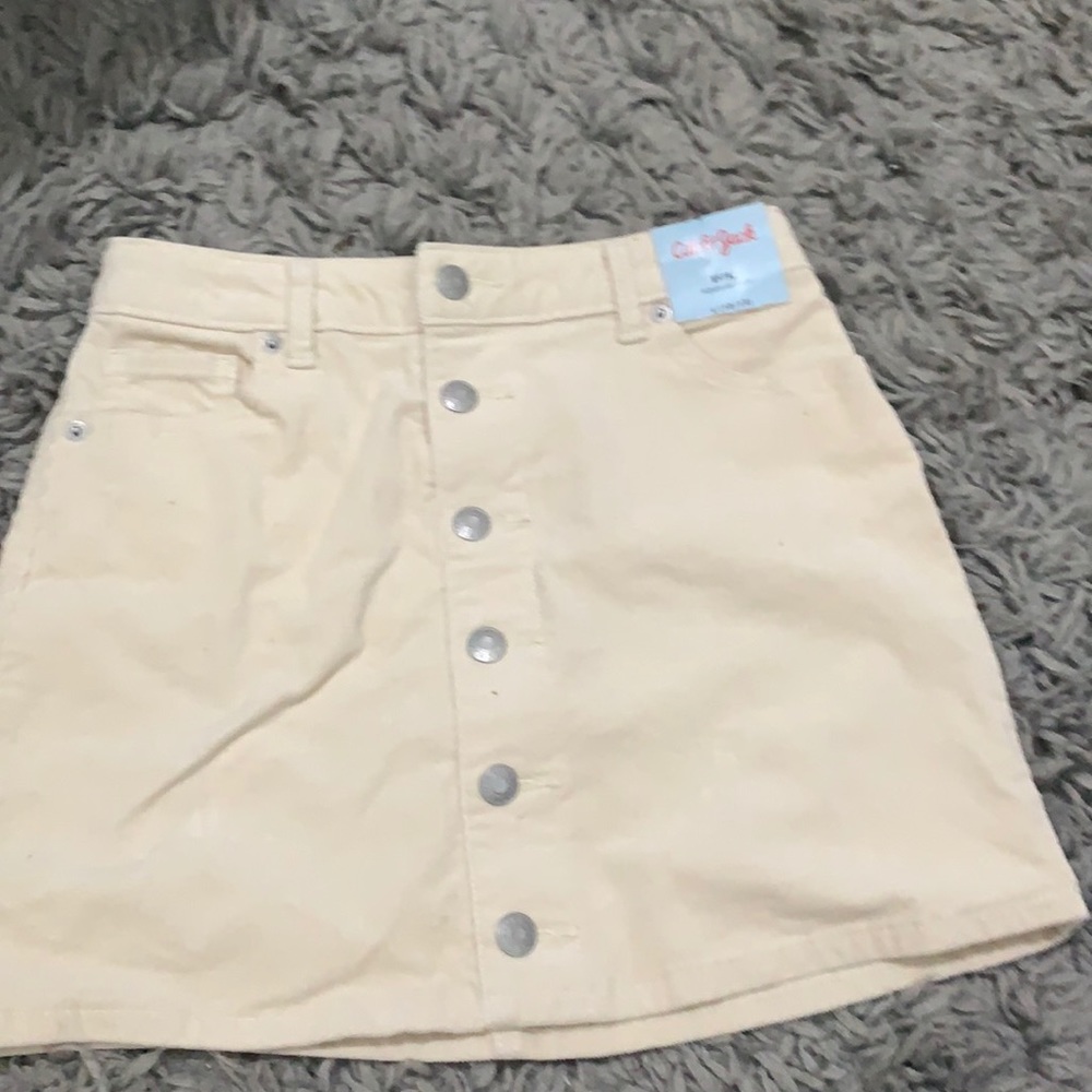 A beige skirt that has adjustable waist from cat and Jack